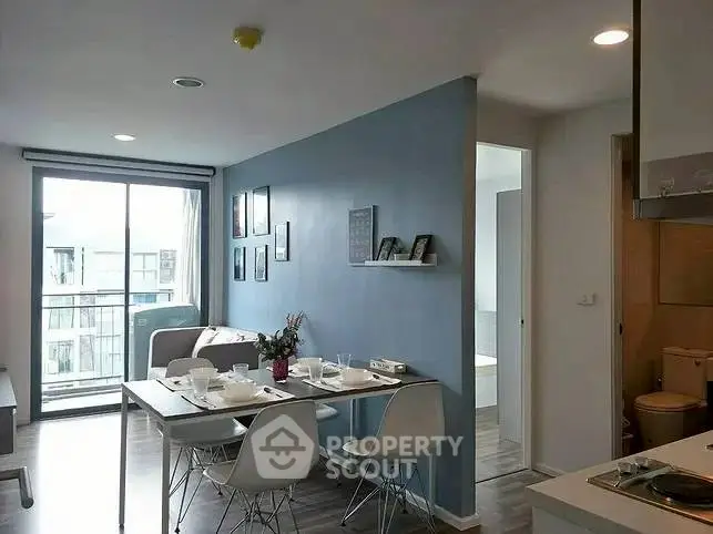 Modern apartment dining area with blue accent wall and natural light