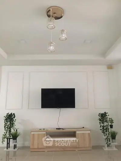 Modern living room with sleek TV setup and elegant lighting, perfect for contemporary homes.