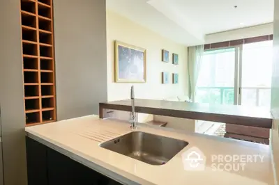 Bright and modern kitchen with sleek countertops, stainless steel sink, and a view of the outdoors through large windows, perfect for culinary enthusiasts.