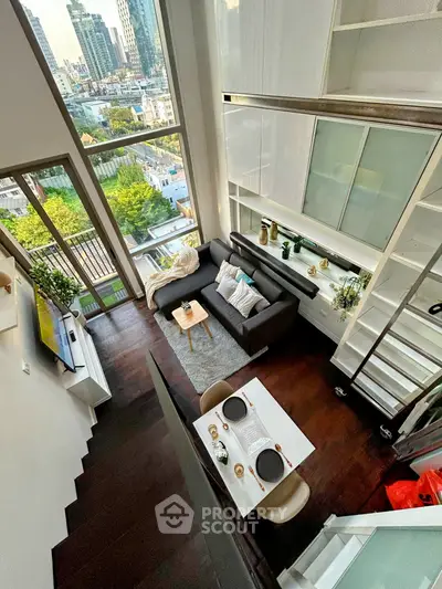 Stunning loft apartment with high ceilings and city view, featuring modern decor and open living space.