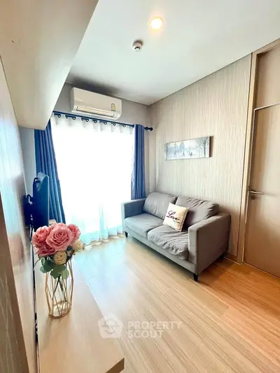 Cozy living room with modern decor and natural light, featuring a comfortable sofa and stylish flooring.