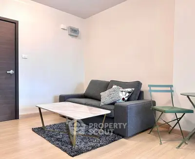 Modern living room with stylish gray sofa and chic coffee table on wooden flooring.