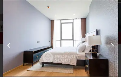 Modern bedroom with stylish furniture and large window offering natural light