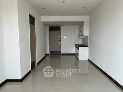 Spacious modern apartment interior with sleek kitchen and glossy tiled floors.