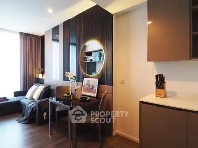 Modern living room with stylish decor and open kitchen layout, featuring elegant furniture and ambient lighting.