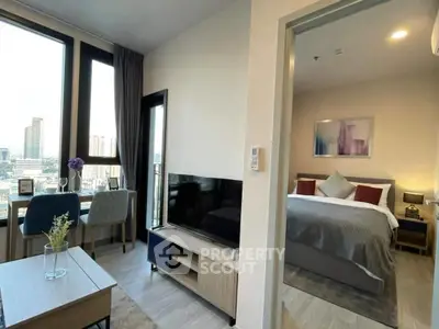 Modern apartment with spacious living area and cozy bedroom, featuring large windows and stylish decor.