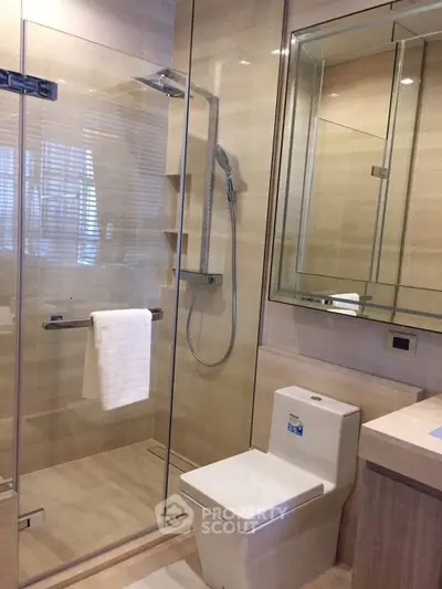 Modern bathroom with glass shower enclosure and sleek fixtures in a contemporary home.