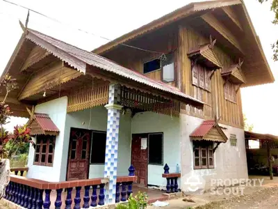 Charming traditional wooden house with intricate roof design and spacious porch.