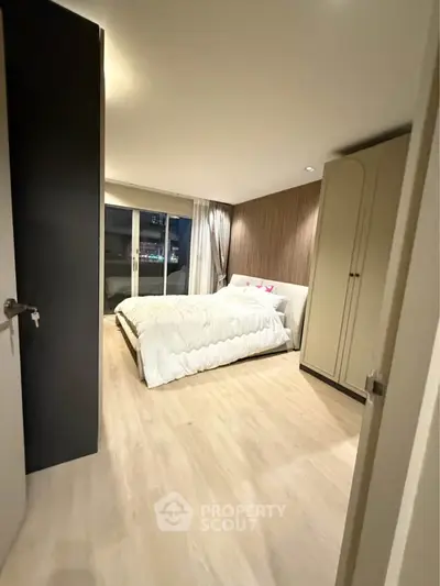 Modern bedroom with cozy lighting and elegant decor, featuring a large bed and stylish wardrobe.