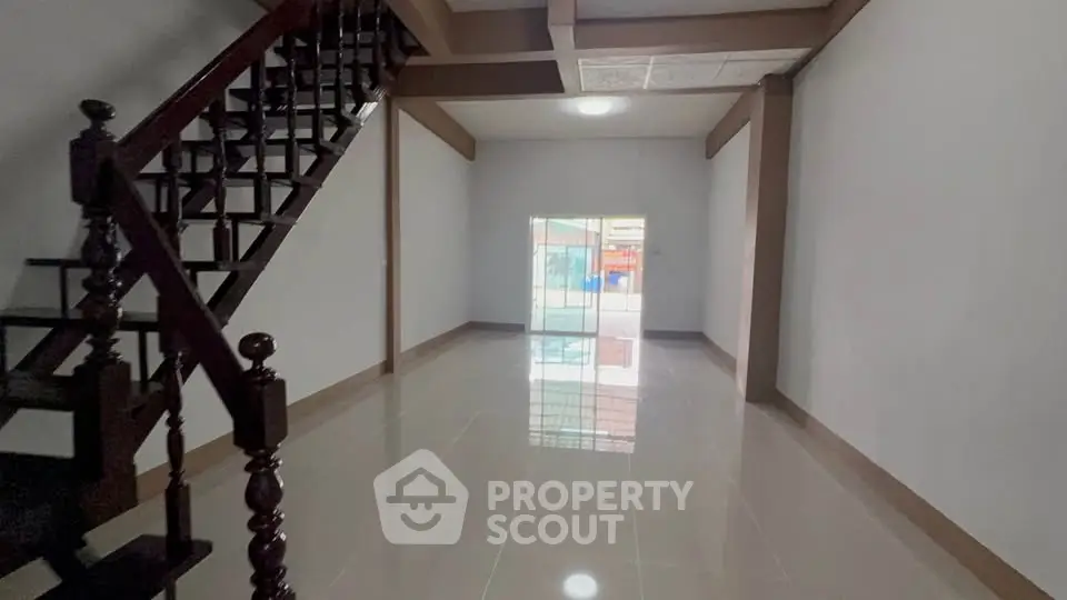 Spacious open-plan living area with staircase and large window