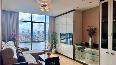 Luxurious living room with stunning city and river view, modern decor, and ample natural light.