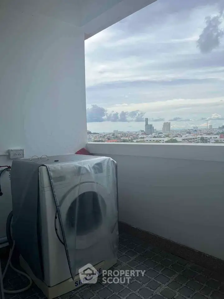 High-rise balcony with washing machine and stunning cityscape view