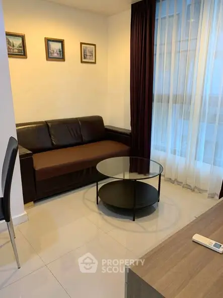 Cozy living room with modern sofa and glass coffee table, perfect for relaxation.
