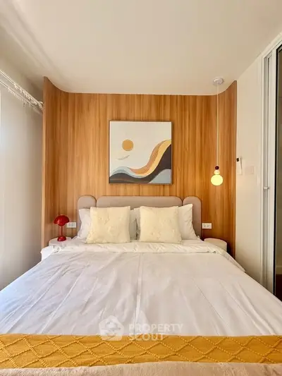Cozy bedroom with modern decor and wooden accent wall, featuring a stylish bed and contemporary artwork.
