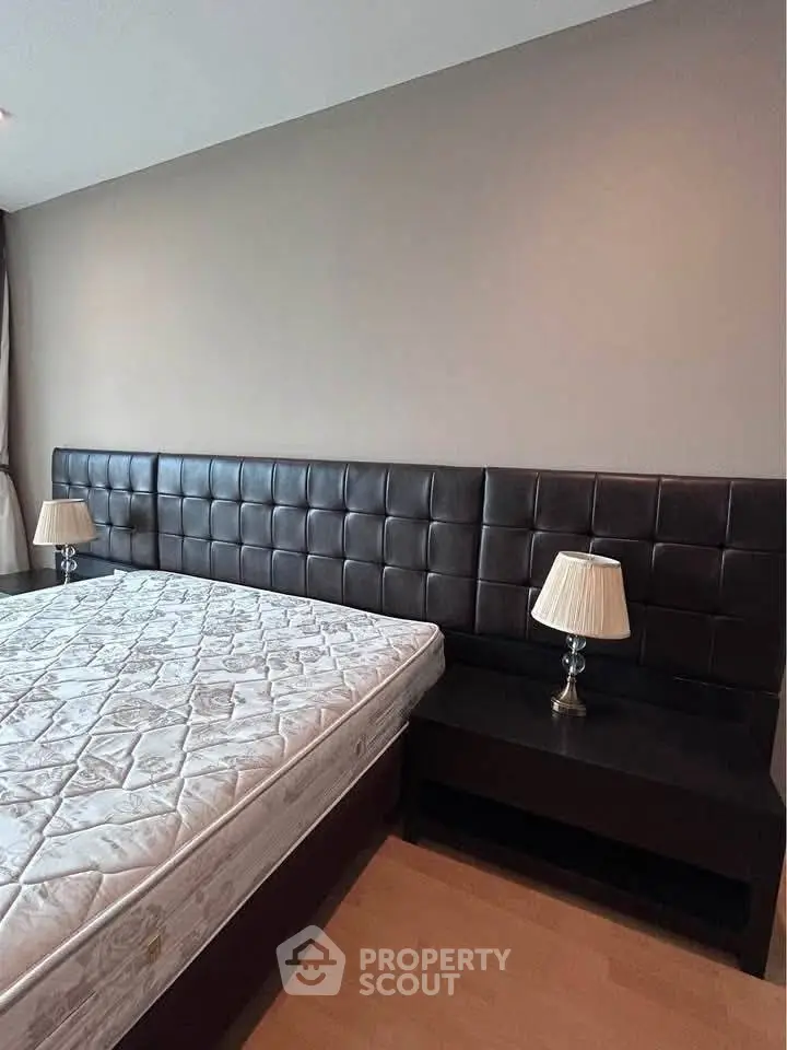 Modern bedroom with stylish headboard and elegant bedside lamps