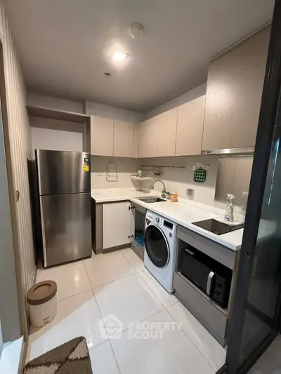 Modern kitchen with sleek appliances and ample storage in a stylish apartment.