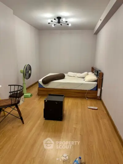 Cozy minimalist bedroom with wooden flooring and modern lighting