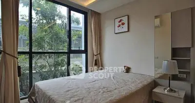 Cozy bedroom with large window and garden view, perfect for relaxation.