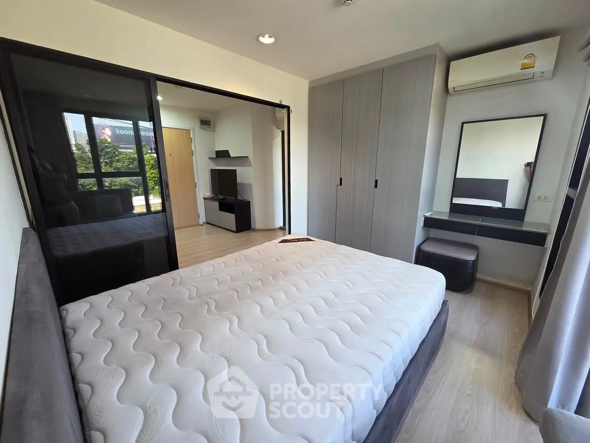 Modern bedroom with large bed, mirrored wardrobe, and air conditioning in a stylish apartment.