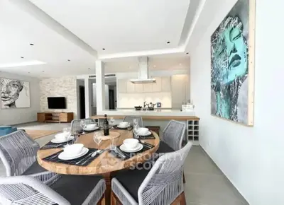 Modern open-plan dining and living area with stylish decor and contemporary art.