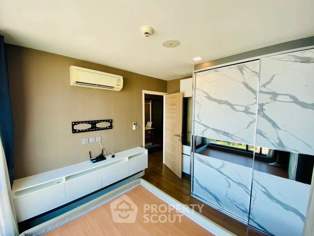 Modern bedroom with stylish wardrobe and air conditioning in a bright apartment.