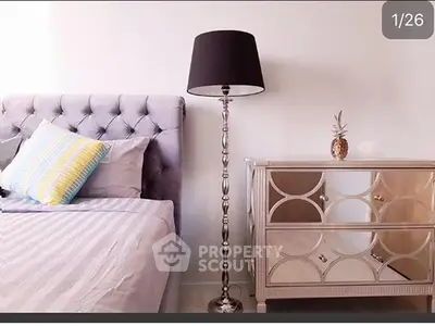 Elegant bedroom with plush headboard and stylish mirrored nightstand