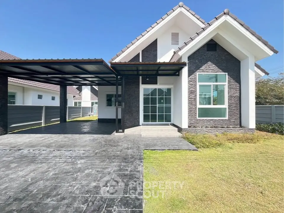 Charming modern house with spacious driveway and lush green lawn under clear blue sky.