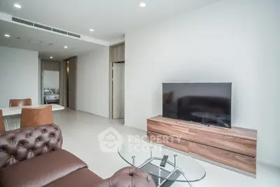 Modern living room with sleek furniture and large TV in a stylish apartment.
