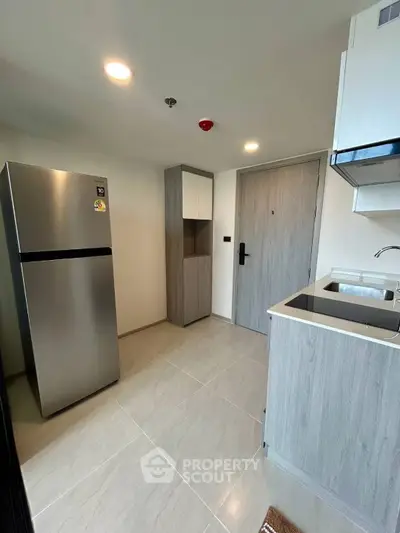 Modern kitchen with sleek appliances and minimalist design in a contemporary apartment.