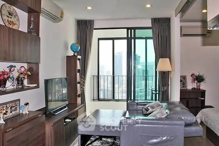 Modern living room with city view, featuring sleek furniture and large windows for natural light.