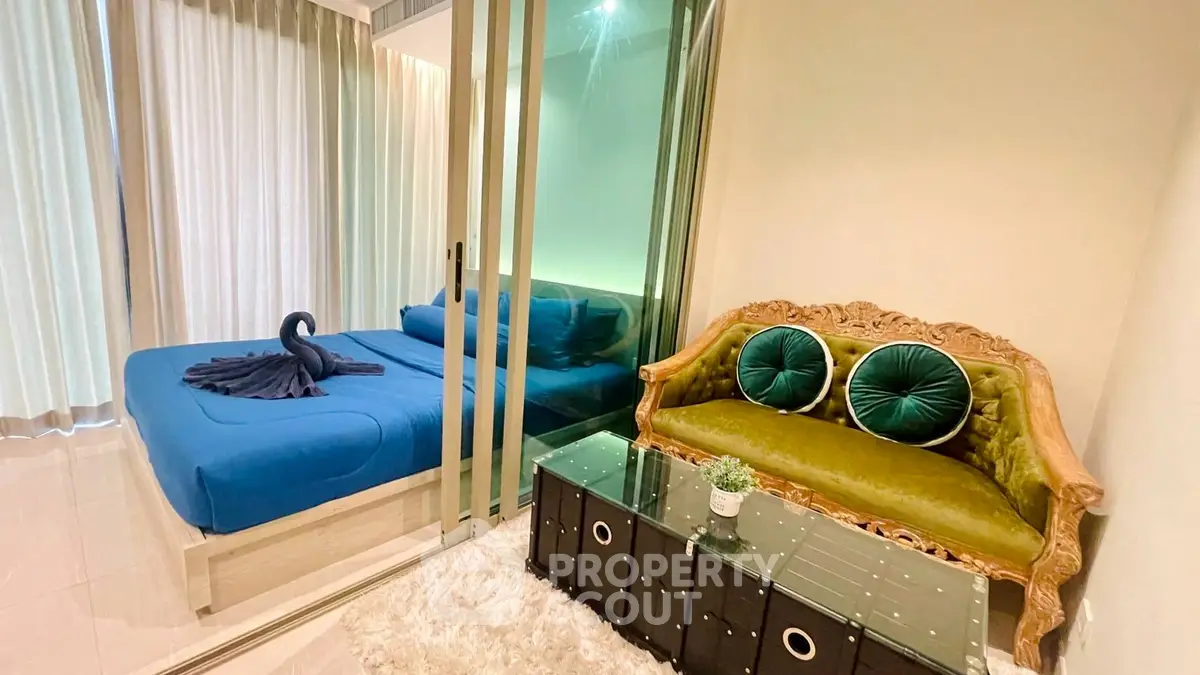 Chic modern bedroom with glass partition and elegant seating area, perfect for urban living.
