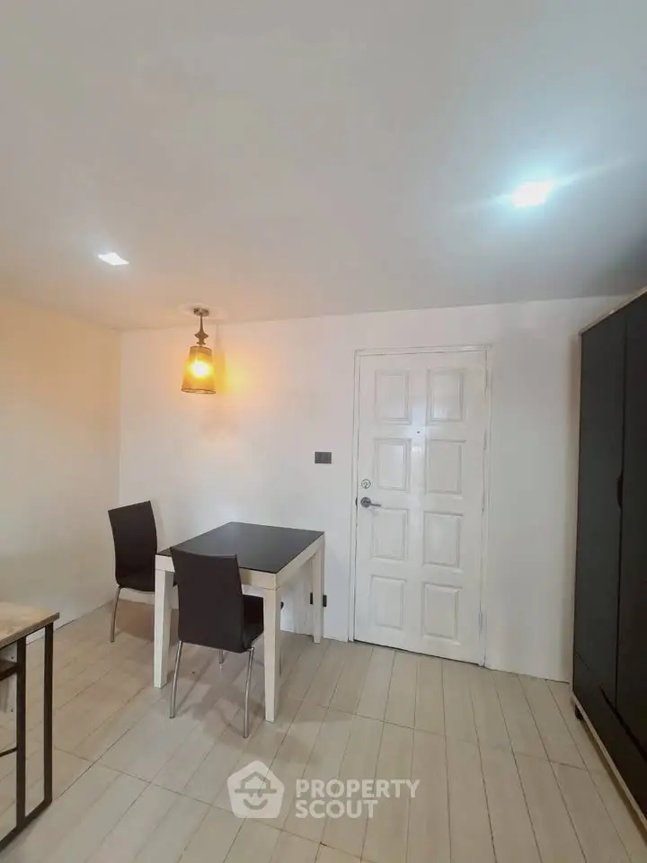 Cozy dining area with modern lighting and minimalist furniture in a stylish apartment.
