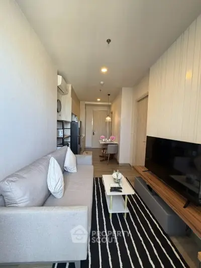 Modern living room with stylish decor and cozy ambiance, featuring a sleek TV setup and elegant furnishings.