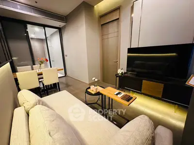 Modern living room with sleek furniture and dining area in a stylish apartment.