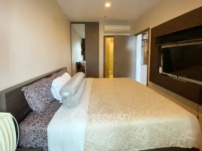 Cozy bedroom with modern decor and wall-mounted TV in a stylish apartment.