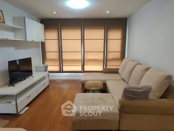 Cozy living room with modern furniture and large windows, perfect for relaxation.