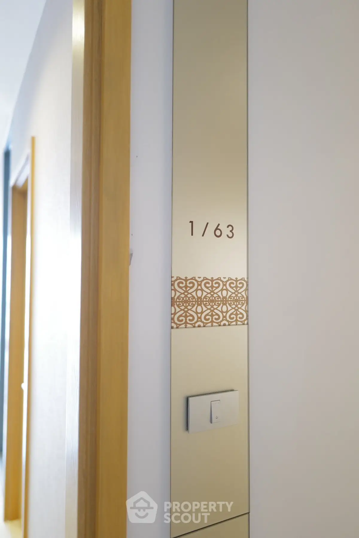 Modern apartment entrance with stylish wall design and room number display.