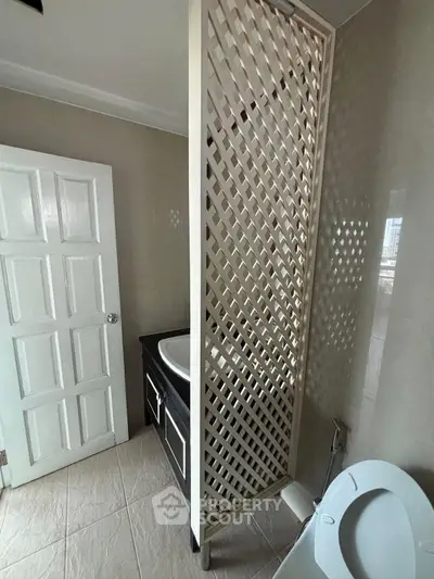 Modern bathroom with unique lattice partition and sleek fixtures