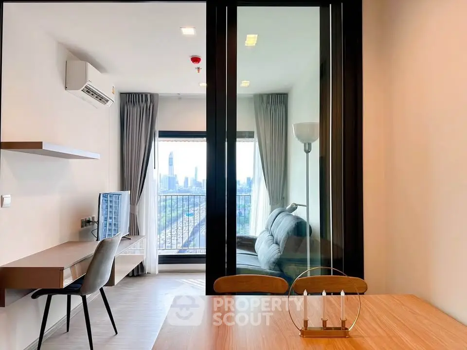 Modern living room with city view, featuring sleek furniture and large windows for natural light.