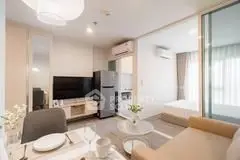 Modern living room with open kitchen and cozy bedroom in stylish apartment.