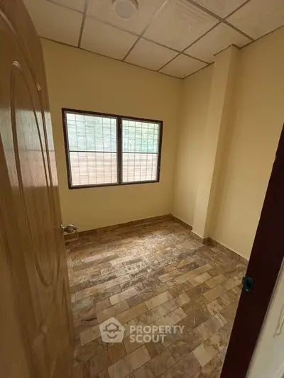 Cozy small room with tiled floor and window, perfect for a study or storage space.