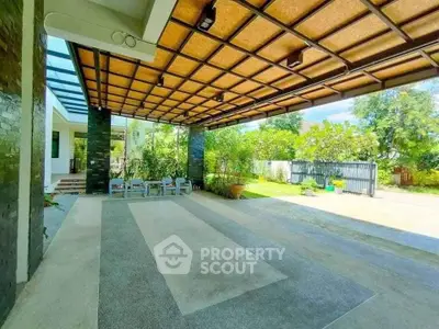 Spacious modern home entrance with covered patio and lush greenery