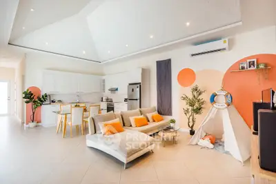 Spacious modern living room with open kitchen, stylish decor, and cozy seating area.