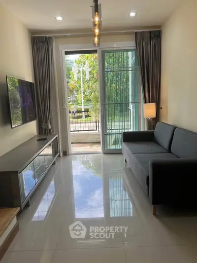 Modern living room with sleek sofa, TV, and large window offering garden view.