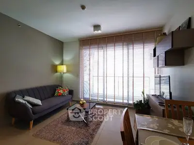 Modern living room with stylish decor and large window blinds, cozy seating area and dining table.