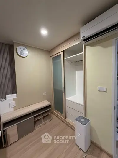 Modern bedroom with built-in wardrobe and air conditioning in a stylish apartment.