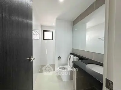 Modern bathroom with sleek fixtures and large mirror in a contemporary home.