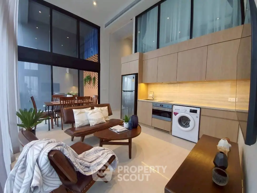 Modern open-plan living room with high ceilings and stylish kitchen appliances