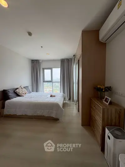 Spacious bedroom with city view, modern furnishings, and ample natural light.
