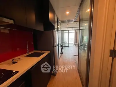 Modern kitchen with sleek design and open layout leading to a bright living area.